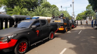 Petugas Kepolisian berjaga di depan Gedung KPU, Jakarta, Rabu (20/3/2024). [Suara.com/Alfian Winanto]