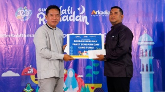 Pemimpin Redaksi Suara.com, Suwarjono (kiri) menyerahkan bantuan CSR kepada Perwakilan Muhammadiyah Rawamangun, Bagus Wira Andriawan (kanan) saat acara Takjil Gratis In Friday (TGIF) Suara Hati Ramadan di SMA Muhammadiyah 11, Jakarta, Jumat (22/3/2024). [Suara.com/Alfian Winanto]