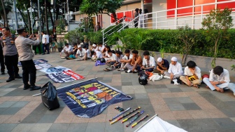 Petugas mengamankan anak-anak saat Razia konvoi kendaraan bermotor di Bundaran HI, Jakarta, Selasa (2/4/2024). [Suara.com/Alfian Winanto]