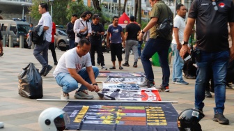 Petugas mengamankan anak-anak saat Razia konvoi kendaraan bermotor di Bundaran HI, Jakarta, Selasa (2/4/2024). [Suara.com/Alfian Winanto]