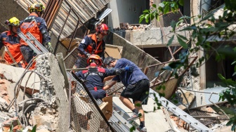 Foto yang diambil oleh Kantor Berita Pusat Taiwan (CNA) menunjukkan pekerja darurat membantu seorang penyintas yang diselamatkan dari reruntuhan bangunan setelah gempa bumi di New Taipei City, Taiwan, Rabu (3/4/2024). [ CNA / AFP]