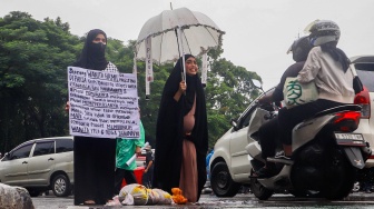 Massa melakukan aksi teaterikal saat menggelar aksi bela Palestina di depan Kedutaan Besar Amerika Serikat, Jakarta, Jumat (5/4//2024). [Suara.com/Alfian Winanto]