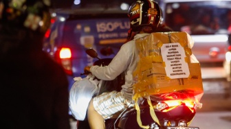 Kertas berisi pesan - pesan terpasang di belakang kendaraan pemudik bersepeda motor yang melintas di Jalan Inspeksi Kalimalang, Jakarta, Sabtu (6/4/2024). [Suara.com/Alfian Winanto]