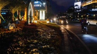 Sejumlah kendaraan melintas di depan dekorasi lebaran di kawasan Bundaran Hotel Indonesia, Jakarta, Senin (8/4/2024). [Suara.com/Alfian Winanto]