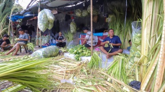 Pedagang menyelesaikan pembuatan kulit ketupat di Pasar Palmerah, Jakarta, Selasa (9/4/2024). [Suara.com/Alfian Winanto]