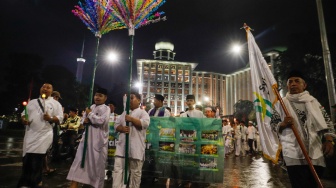 Sejumlah warga melakukan pawai obor malam takbiran di kawasan Masjid Istiqlal, Jakarta, Selasa (9/4/2024). [Suara.com/Alfian Winanto]