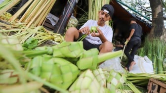 Pedagang menyelesaikan pembuatan kulit ketupat di Pasar Palmerah, Jakarta, Selasa (9/4/2024). [Suara.com/Alfian Winanto]