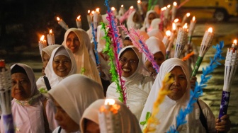 Sejumlah warga melakukan pawai obor malam takbiran di kawasan Masjid Istiqlal, Jakarta, Selasa (9/4/2024). [Suara.com/Alfian Winanto]