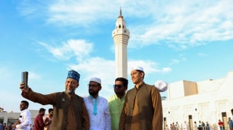 Warga Muslim berfoto selfie setelah salat Idul Fitri, yang menandai akhir bulan suci Ramadhan, di masjid Ali Bin Ali di Doha, Qatar, Rabu (10/4/2024). [KARIM JAAFAR / AFP]