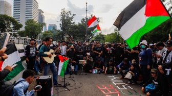 Sejumlah musisi tampil saat menggelar aksi solidaritas untuk Palestina di depan Kantor Kedutaan Besar Amerika Serikat, Jakarta, Jumat (19/4/2024). [Suara.com/Alfian Winanto]