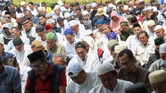 Massa menggelar salat jumat berjamaah saat aksi tolak pemilu curang di Patung Kuda, Jakarta, Jumat (19/4/2024). [Suara.com/Alfian Winanto]