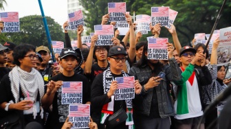 Sejumlah massa mengangkat poster saat menggelar aksi solidaritas untuk Palestina di depan Kantor Kedutaan Besar Amerika Serikat, Jakarta, Jumat (19/4/2024). [Suara.com/Alfian Winanto]