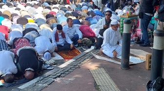 Gelar Aksi Kawal Sidang MK di Patung Kuda, Massa Salat Berjamaah di Jalan