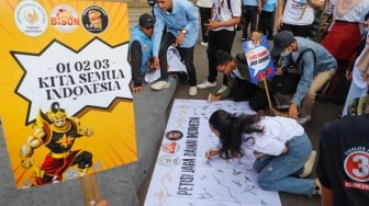 Massa relawan menandatangani Petisi Jaga Damai Indonesia di Kawasan Patung Kuda, Jakarta, Selasa (23/4/2024). [Suara.com/Alfian Winanto]