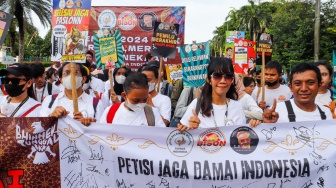 Massa relawan saat menggelar Aksi Jaga Damai Indonesia di Kawasan Patung Kuda, Jakarta, Selasa (23/4/2024). [Suara.com/Alfian Winanto]