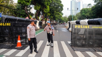 Petugas Kepolisian melakukan penjagaan di Gedung Komisi Pemilihan Umum (KPU) RI, Jakarta, Rabu (24/4/2024). [Suara.com/Alfian Winanto]