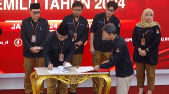 Ketua KPU Hasyim Asy'ari (tengah) menandatangi berita acara Rapat Pleno Terbuka Penetapan Pasangan Capres-Cawapres Terpilih di Gedung KPU, Jakarta, Rabu (24/4/2024). [Suara.com/Alfian Winanto]