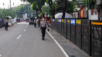 Petugas Kepolisian melakukan penjagaan di Gedung Komisi Pemilihan Umum (KPU) RI, Jakarta, Rabu (24/4/2024). [Suara.com/Alfian Winanto]