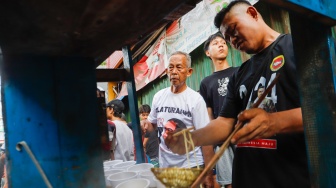 Warga mengantre mie ayam gratis di wilayah Menteng Wadas Timur, Jakarta, Selasa (30/4/2024). [Suara.com/Alfian Winanto]