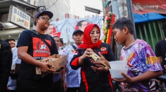 Relawan Jokowi membagikan susu kepada anak-anak di wilayah Menteng Wadas Timur, Jakarta, Selasa (30/4/2024). [Suara.com/Alfian Winanto]