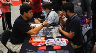 Pengunjung bermain Trading Card Game (TCG) di gelaran Anime Festival Asia Indonesia (AFAID) di  JCC Senayan, Jakarta, Jumat (3/5/2024). [Suara.com/Alfian Winanto]