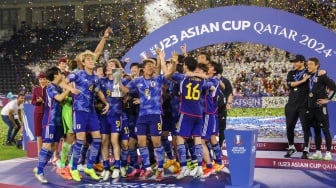 Para pemain Jepang selebrasi dan mengangkat trofi setelah memenangkan pertandingan final Piala Asia U23 2024 antara Jepang melawan Uzbekistan di Stadion Jassim Bin Hamad, Doha, Qatar, Jumat (3/5/2024). [KARIM JAAFAR / AFP]