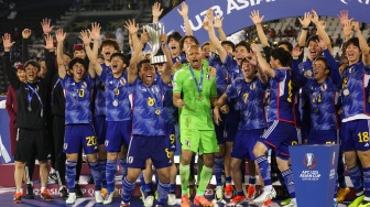 Para pemain Jepang selebrasi dan mengangkat trofi setelah memenangkan pertandingan final Piala Asia U23 2024 antara Jepang melawan Uzbekistan di Stadion Jassim Bin Hamad, Doha, Qatar, Jumat (3/5/2024). [KARIM JAAFAR / AFP]
