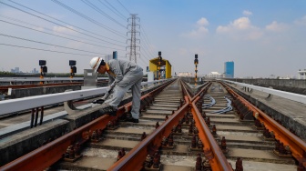 Pekerja melakukan pengecekan arus listrik pada jalur Light Rail Transit (LRT) Jakarta di Depo LRT Jakarta Pegangsaan Dua, Jakarta, Rabu (8/5/2024). [Suara.com/Alfian Winanto]