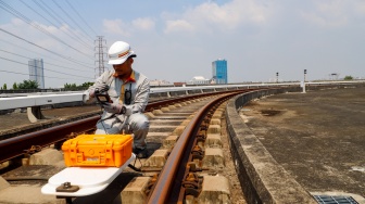 Pekerja melakukan pengecekan Wessel pada jalur Light Rail Transit (LRT) Jakarta di Depo LRT Jakarta Pegangsaan Dua, Jakarta, Rabu (8/5/2024). [Suara.com/Alfian Winanto]