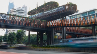 Warga mengunjungi Jembatan Penyebrangan Orang (JPO) Pinisi di Jalan Jenderal Sudirman, Jakarta, Jumat (10/5/2024). [Suara.com/Alfian Winanto]