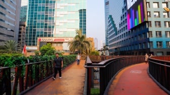 Warga mengunjungi Jembatan Penyebrangan Orang (JPO) Pinisi di Jalan Jenderal Sudirman, Jakarta, Jumat (10/5/2024). [Suara.com/Alfian Winanto]