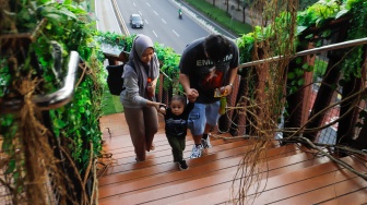 Warga mengunjungi Jembatan Penyebrangan Orang (JPO) Pinisi di Jalan Jenderal Sudirman, Jakarta, Jumat (10/5/2024). [Suara.com/Alfian Winanto]