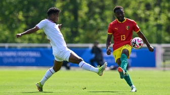 Bek Indonesia Bagas Kaffa (Kiri) berebut bola dengan bek Guinea Madiou Keita selama pertandingan play-off pra-Olimpiade antara Indonesia dan Guinea di Clairefontaine-en-Yvelines, selatan Paris, Prancis, Kamis (9/5/2024). [MIGUEL MEDINA / AFP]