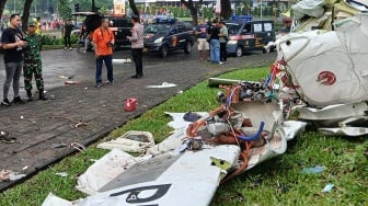 Sejumlah petugas berada di samping puing-puing pesawat yang jatuh di BSD Serpong, Tangerang Selatan, Banten, Minggu (18/5/2024). [ANTARA FOTO/Rais Fauzan Azhar/Bal/YU]