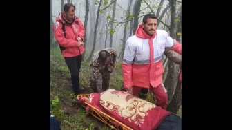 Gambar yang diambil dari cuplikan video ini menunjukkan tim penyelamat menemukan jenazah di lokasi jatuhnya helikopter Presiden Ebrahim Raisi di daerah pegunungan yang diselimuti kabut di barat laut Iran, Senin (20/5/2024). [Palang Merah Iran / AFP]