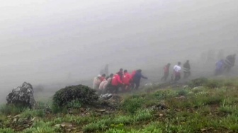 Gambar yang diambil dari cuplikan video ini menunjukkan tim penyelamat menemukan jenazah di lokasi jatuhnya helikopter Presiden Ebrahim Raisi di daerah pegunungan yang diselimuti kabut di barat laut Iran, Senin (20/5/2024). [Palang Merah Iran / AFP]