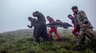 Tim penyelamat mengevakuasi jenazah di lokasi jatuhnya helikopter yang mengangkut Presiden Iran di daerah pegunungan Varzaghan di barat laut Iran, Senin (20/5/2024). [Azin HAGHIGHI / MOJ News Agency / AFP]