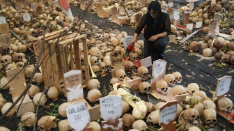 Aktivis hak asasi manusia (HAM) menabur bunga di instalasi Peringatan 26 Tahun Reformasi di kawasan Menteng, Jakarta Pusat, Selasa (21/5/2024). [Suara.com/Alfian Winanto]