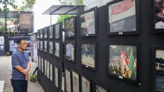 Aktivis hak asasi manusia (HAM) melihat pameran foto Peringatan 26 Tahun Reformasi di kawasan Menteng, Jakarta Pusat, Selasa (21/5/2024). [Suara.com/Alfian Winanto]