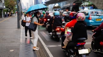 Pekerja melintas di kawasan Perkantoran Sudirman, Jakarta, Selasa (28/5/2024). [Suara.com/Alfian Winanto]