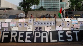 Sejumlah poster terpasang di barier saat aksi solidaritas untuk Palestina di depan Kedutaan Besar Amerika untuk Indonesia, Jakarta, Jumat (31/5/2024). [Suara.com/Alfian Winanto]