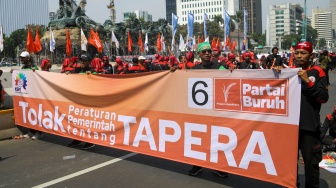 Buruh melakukan aksi unjuk rasa di kawasan Patung Kuda Arjuna Wiwaha, Jalan Medan Merdeka Barat, Jakarta, Kamis (6/6/2024). [Suara.com/Alfian Winanto]
