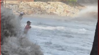 Bagaikan Aang, Bapak-bapak Ini Malah Menyambut Ombak Pasang di Pantai Kuta