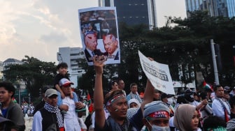 Massa mengangkat poster saat Aksi Bela Palestina di Kawasan Patung Kuda, Jakarta, Minggu (9/6/2024). [Suara.com/Alfian Winanto]