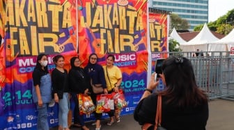 Pengunjung berswafoto di area Jakarta Fair 2024 di JIExpo Kemayoran, Jakarta, Kamis (13/6/2024). [Suara.com/Alfian Winanto]