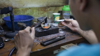 Perajin menyelesaikan pembuatan cincin di Metro Pasar Baru, Jakarta Pusat, Jumat (14/6/2024). [Suara.com/Alfian Winanto]