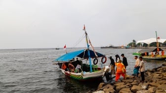 Pengunjung berwisata di Pantai Lagoon, Ancol Taman Impian, Jakarta, Selasa (18/6/2024). [Suara.com/Alfian Winanto]