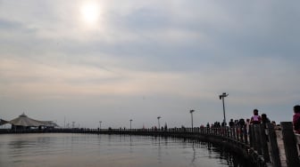 Pengunjung berwisata di Pantai Lagoon, Ancol Taman Impian, Jakarta, Selasa (18/6/2024). [Suara.com/Alfian Winanto]