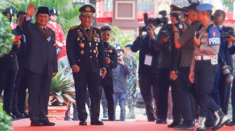 Menteri Pertahanan dan Presiden Terpilih Prabowo Subianto (kiri) didampingi Kapolri Jenderal Pol Listyo Sigit Prabowo (kanan) menyapa awak media di Mabes Polri, Jakarta, Kamis (20/6/2024). [Suara.com/Alfian Winanto]