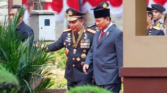 Menteri Pertahanan dan Presiden Terpilih Prabowo Subianto (kanan) didampingi Kapolri Jenderal Pol Listyo Sigit Prabowo (kiri) saat tiba di Mabes Polri, Jakarta, Kamis (20/6/2024). [Suara.com/Alfian Winanto]